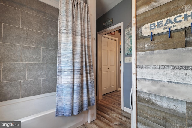 bathroom with shower / bath combo with shower curtain and wood-type flooring