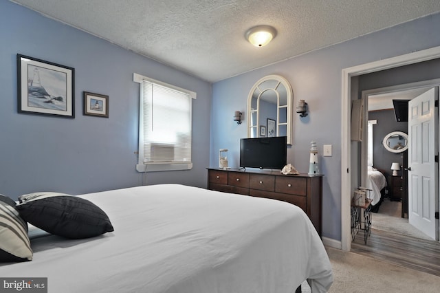 bedroom with carpet floors and a textured ceiling