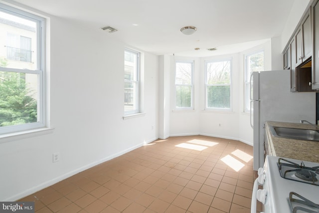 kitchen featuring range, light tile patterned floors, and a healthy amount of sunlight