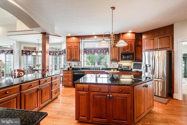 kitchen featuring black appliances, pendant lighting, light hardwood / wood-style flooring, and a kitchen island