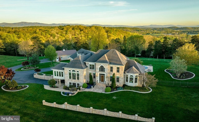 birds eye view of property with a mountain view and a wooded view