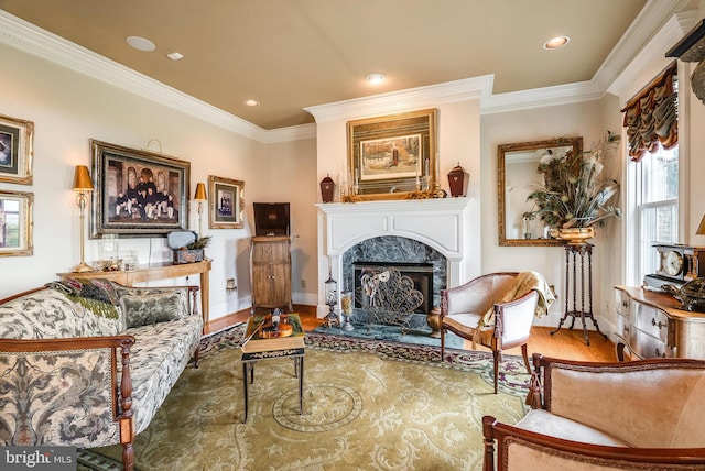 living area featuring a high end fireplace, ornamental molding, a healthy amount of sunlight, and wood-type flooring