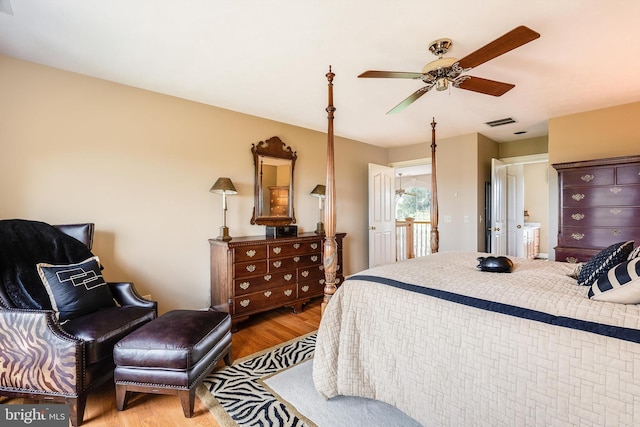 bedroom featuring light wood-style floors, visible vents, and ceiling fan