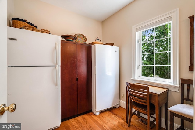 kitchen featuring light wood-type flooring and freestanding refrigerator