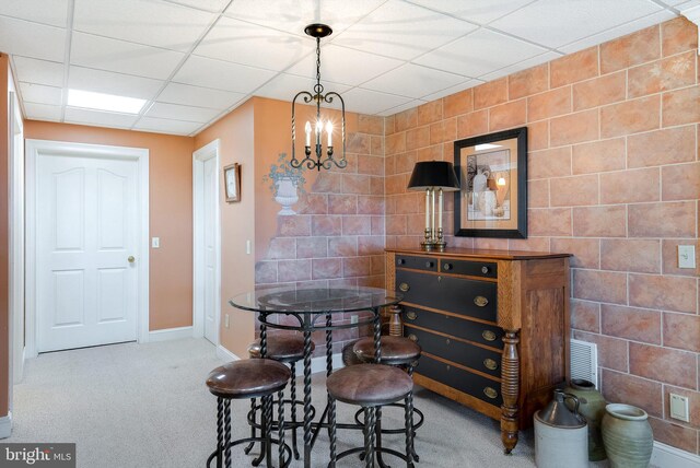 dining room with a drop ceiling, tile walls, and carpet