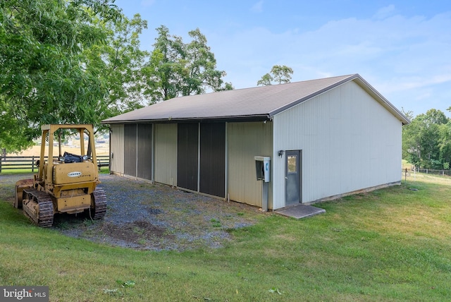 exterior space with metal roof, a yard, an outdoor structure, and fence