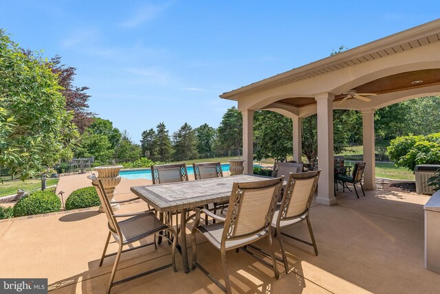 view of patio / terrace featuring a ceiling fan, an outdoor pool, and outdoor dining area