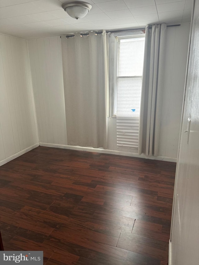 unfurnished room with dark hardwood / wood-style flooring