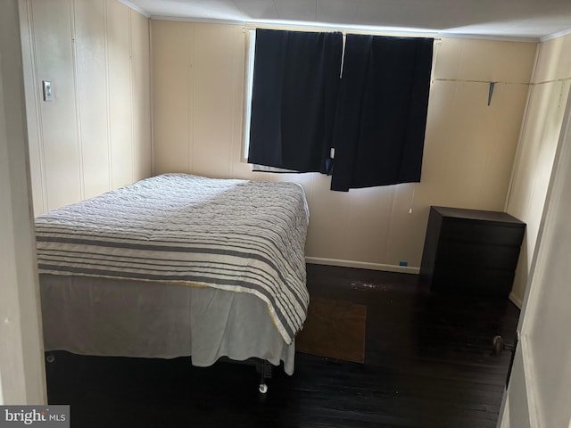 bedroom with crown molding and dark hardwood / wood-style floors