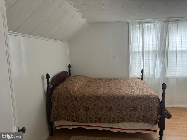 bedroom with vaulted ceiling and wood-type flooring