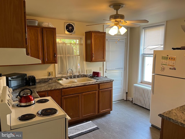 kitchen with sink, white appliances, and radiator heating unit