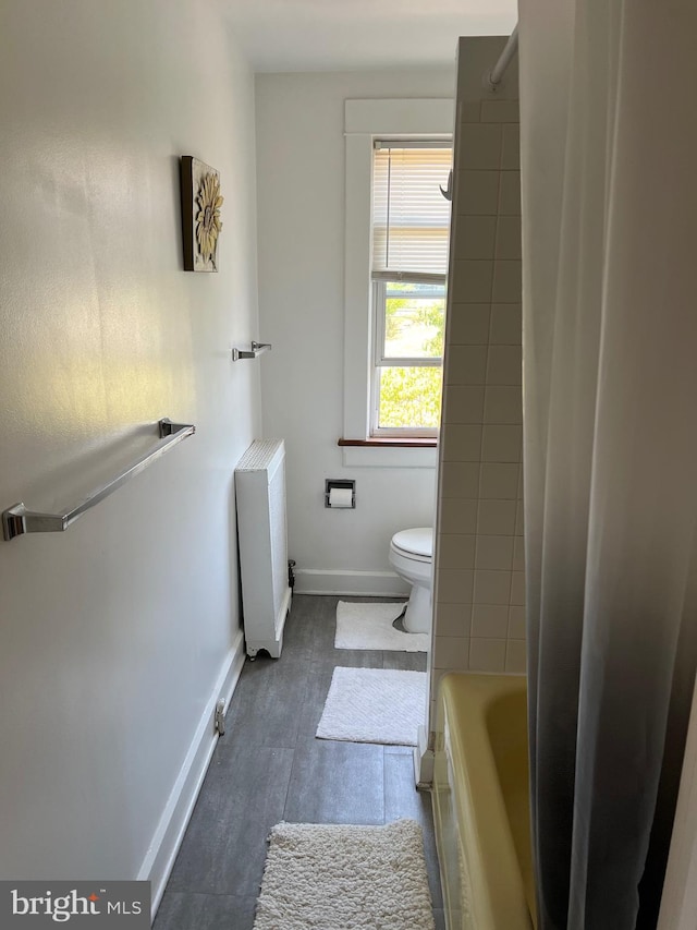 bathroom featuring radiator heating unit and toilet