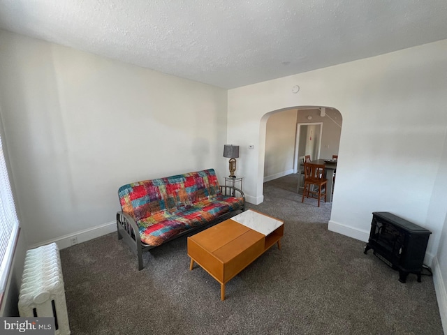 living room with dark carpet and a textured ceiling