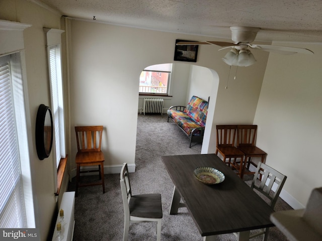 carpeted dining space with radiator heating unit, ceiling fan, and a textured ceiling