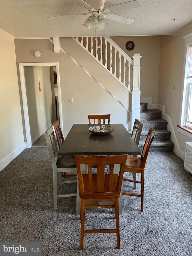 dining area featuring carpet, a textured ceiling, and ceiling fan