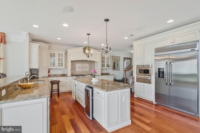 kitchen featuring light hardwood / wood-style flooring, appliances with stainless steel finishes, sink, and kitchen peninsula