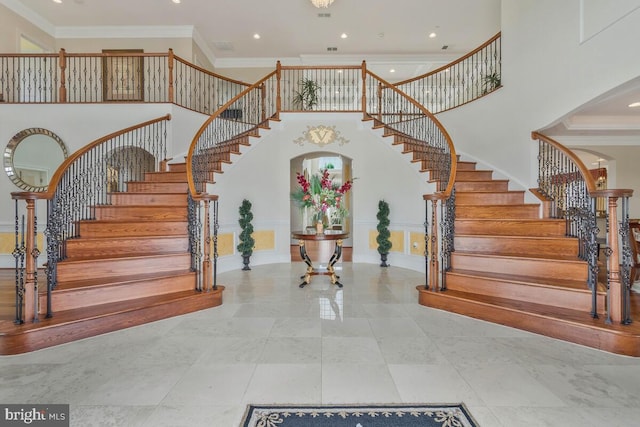 stairway featuring a towering ceiling, tile patterned floors, and ornamental molding