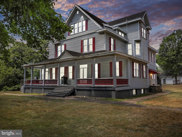 view of front of house featuring covered porch and a lawn