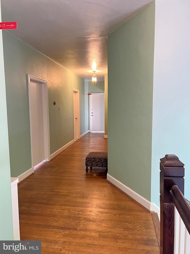 corridor featuring hardwood / wood-style floors and a textured ceiling