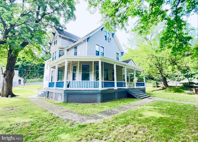 rear view of house featuring a yard and covered porch