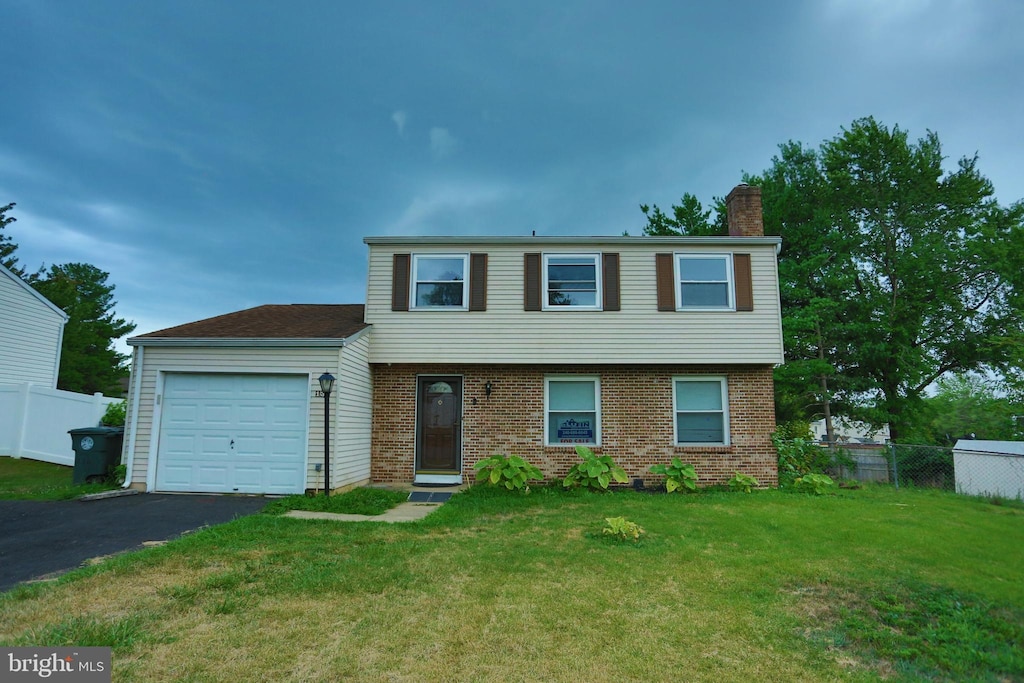 view of front of property featuring a garage and a front lawn