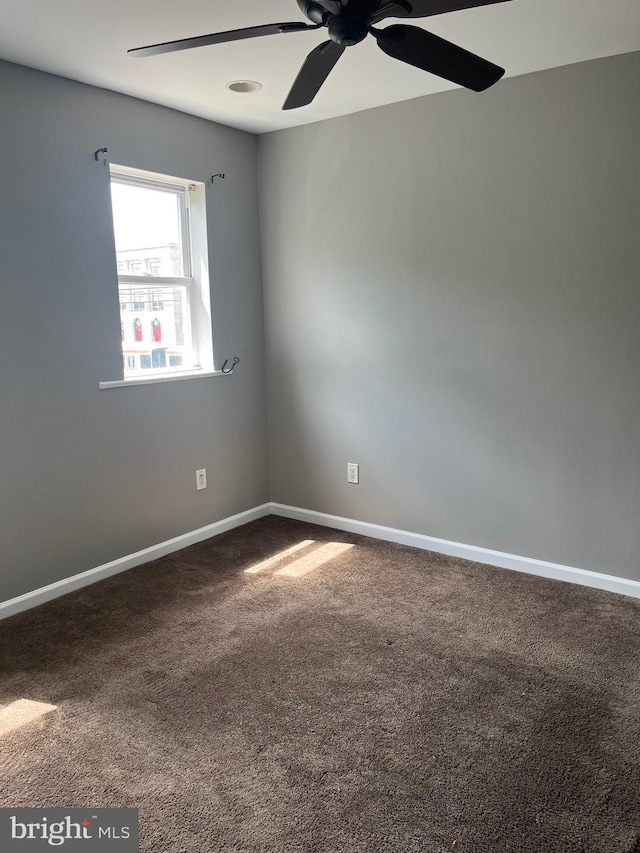 carpeted spare room with ceiling fan