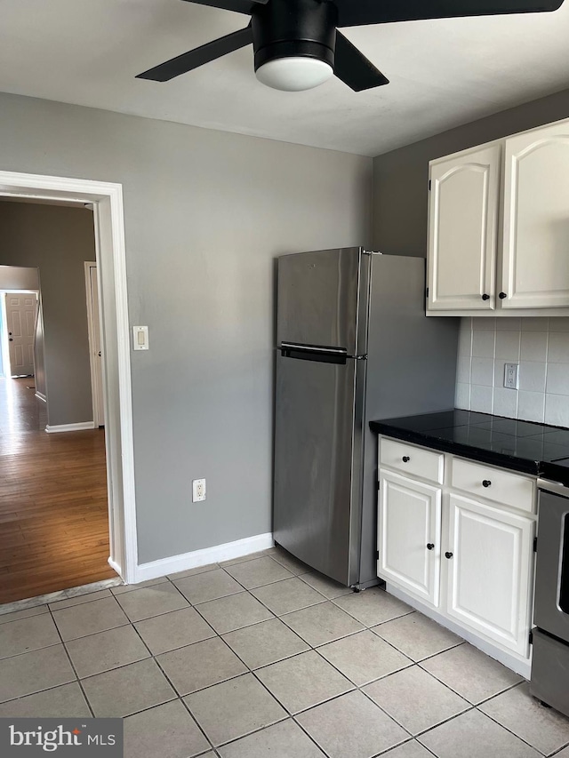 kitchen with light tile patterned flooring, tasteful backsplash, ceiling fan, range, and white cabinets