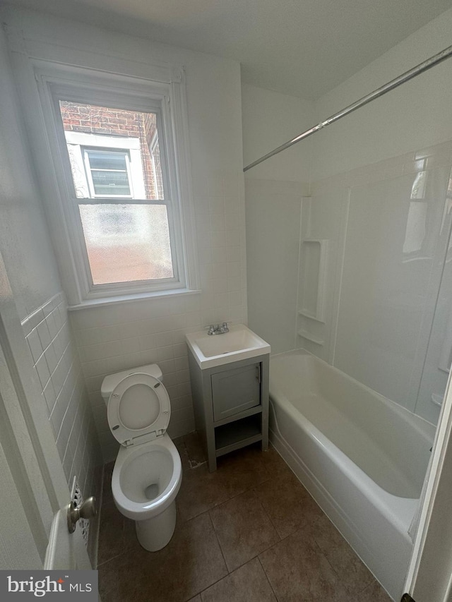 full bathroom with toilet, tub / shower combination, tile walls, vanity, and tile patterned flooring