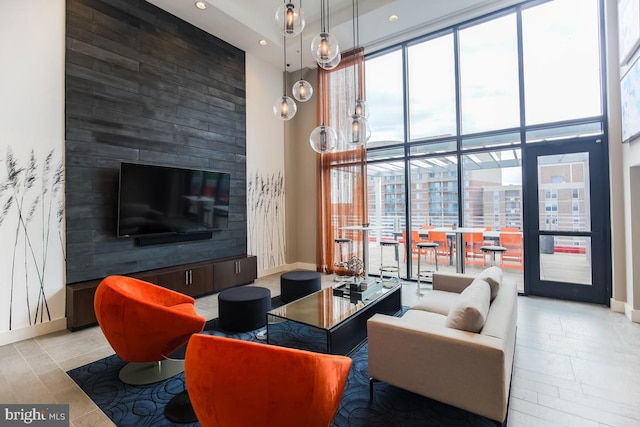 living room featuring a high ceiling, expansive windows, and a wealth of natural light