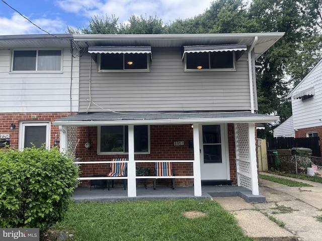 view of front of house featuring brick siding and fence