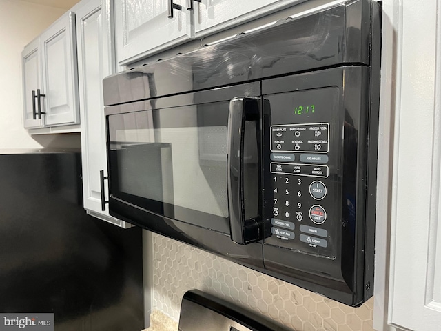 details featuring black microwave and white cabinets