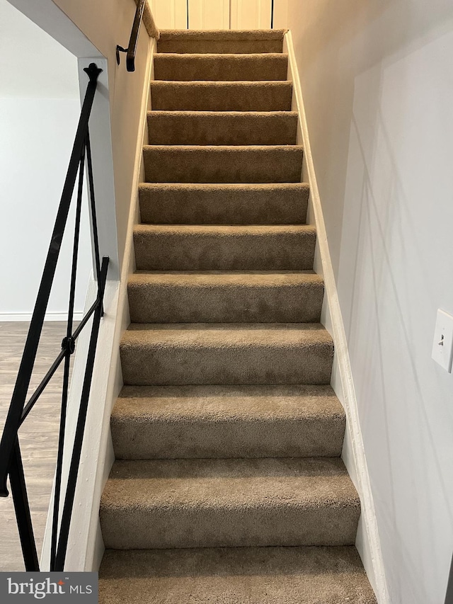 stairway with baseboards and wood finished floors