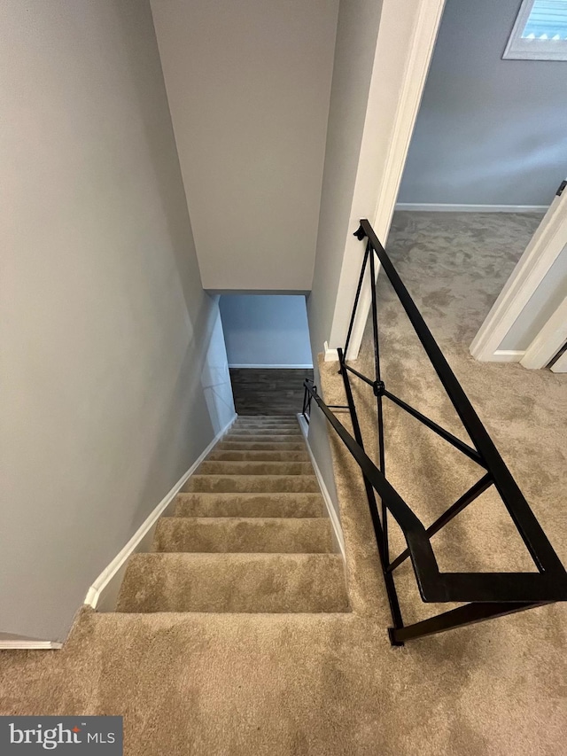 stairs with carpet floors and baseboards