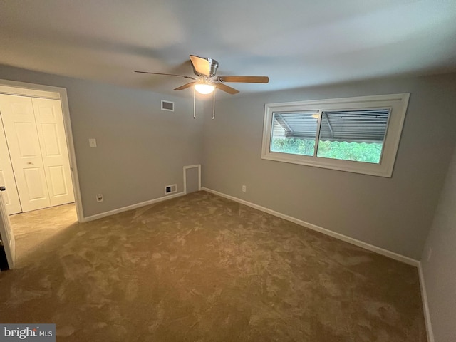 empty room with carpet, visible vents, ceiling fan, and baseboards