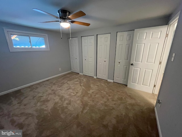 unfurnished bedroom featuring ceiling fan, carpet floors, and multiple closets