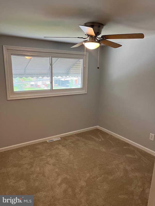 spare room featuring carpet flooring, ceiling fan, and a healthy amount of sunlight