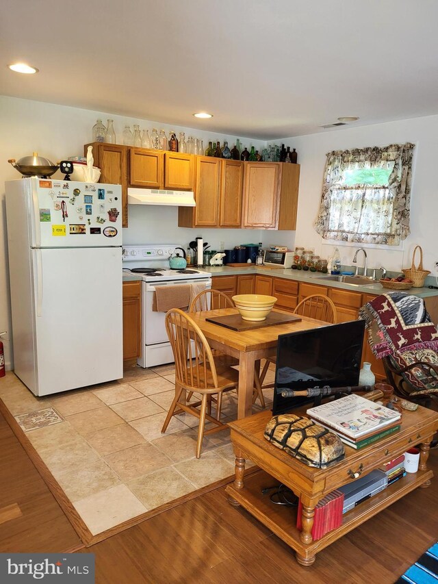 kitchen with sink, light hardwood / wood-style floors, and white appliances