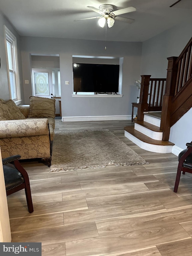 living room with light wood-type flooring and ceiling fan