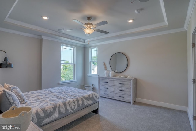 bedroom with a raised ceiling, light colored carpet, and baseboards