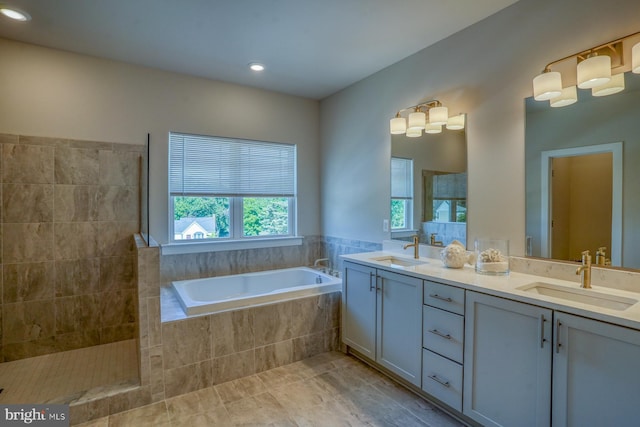 full bath with a sink, tile patterned floors, double vanity, and a garden tub