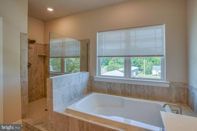 bathroom featuring recessed lighting, a bath, and walk in shower