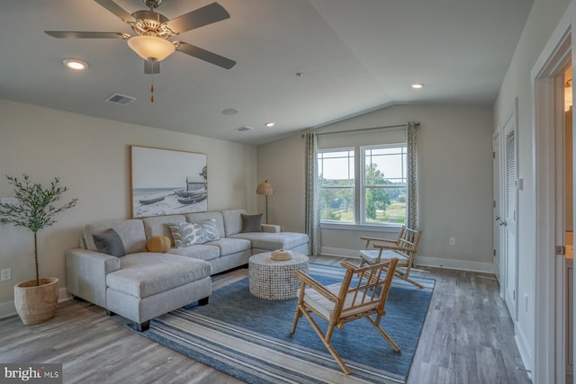 living room featuring hardwood / wood-style flooring, vaulted ceiling, and ceiling fan