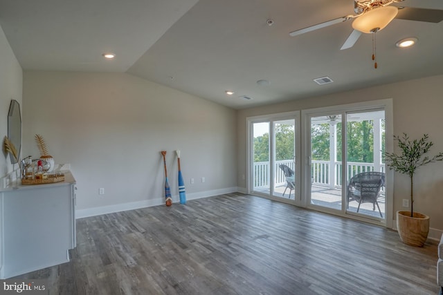 unfurnished living room with vaulted ceiling, visible vents, baseboards, and wood finished floors