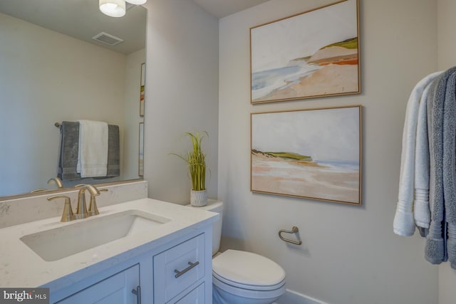 bathroom with vanity, toilet, and visible vents