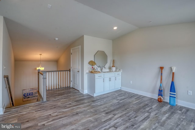 interior space featuring sink, lofted ceiling, and hardwood / wood-style floors