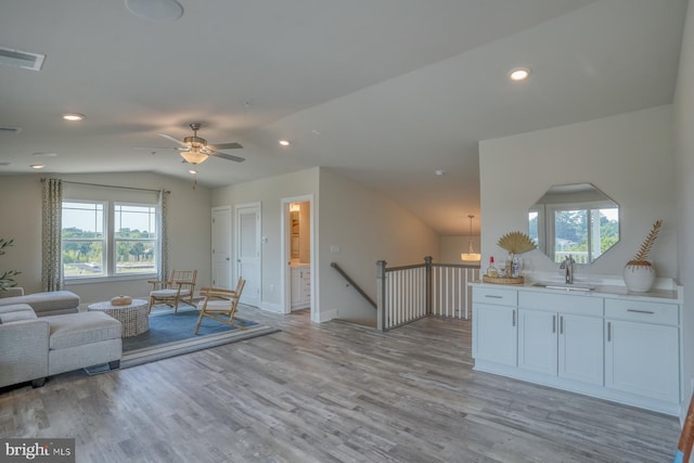 living area featuring visible vents, recessed lighting, light wood finished floors, and vaulted ceiling