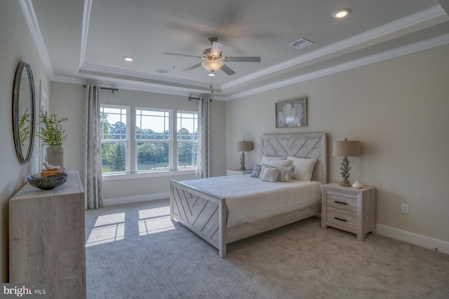 carpeted bedroom with crown molding, ceiling fan, and a raised ceiling