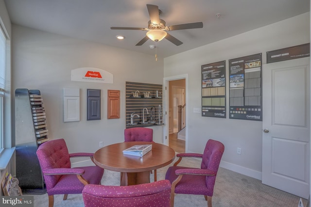 carpeted dining space with ceiling fan