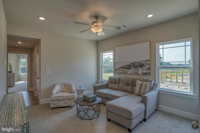 living room featuring light carpet and ceiling fan