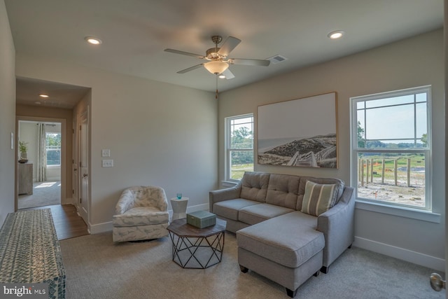 living area with visible vents, light colored carpet, a wealth of natural light, and recessed lighting